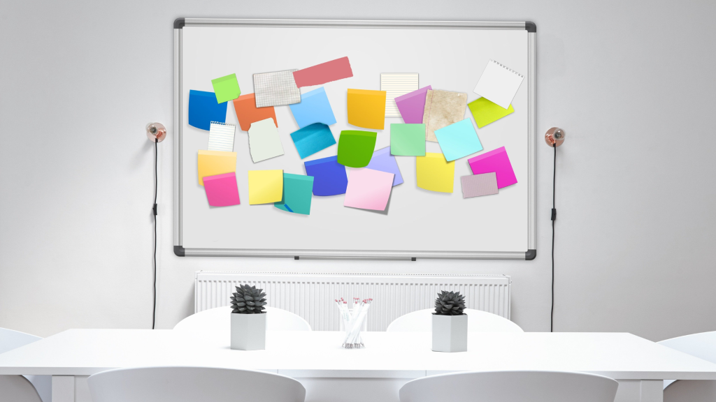 A white board filled with post it notes in lots of colours