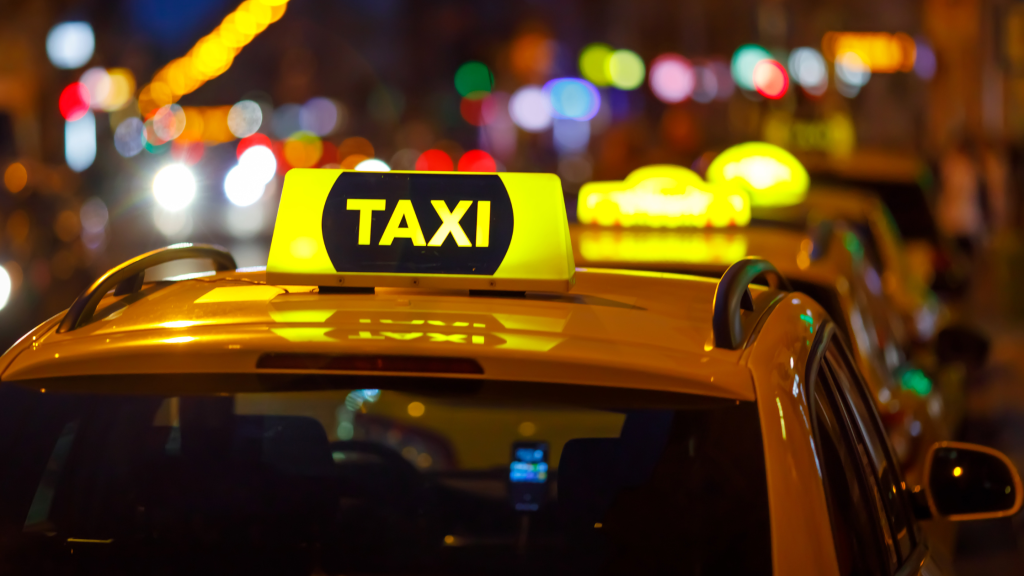 Yellow taxi cab with city lights blurred in the background